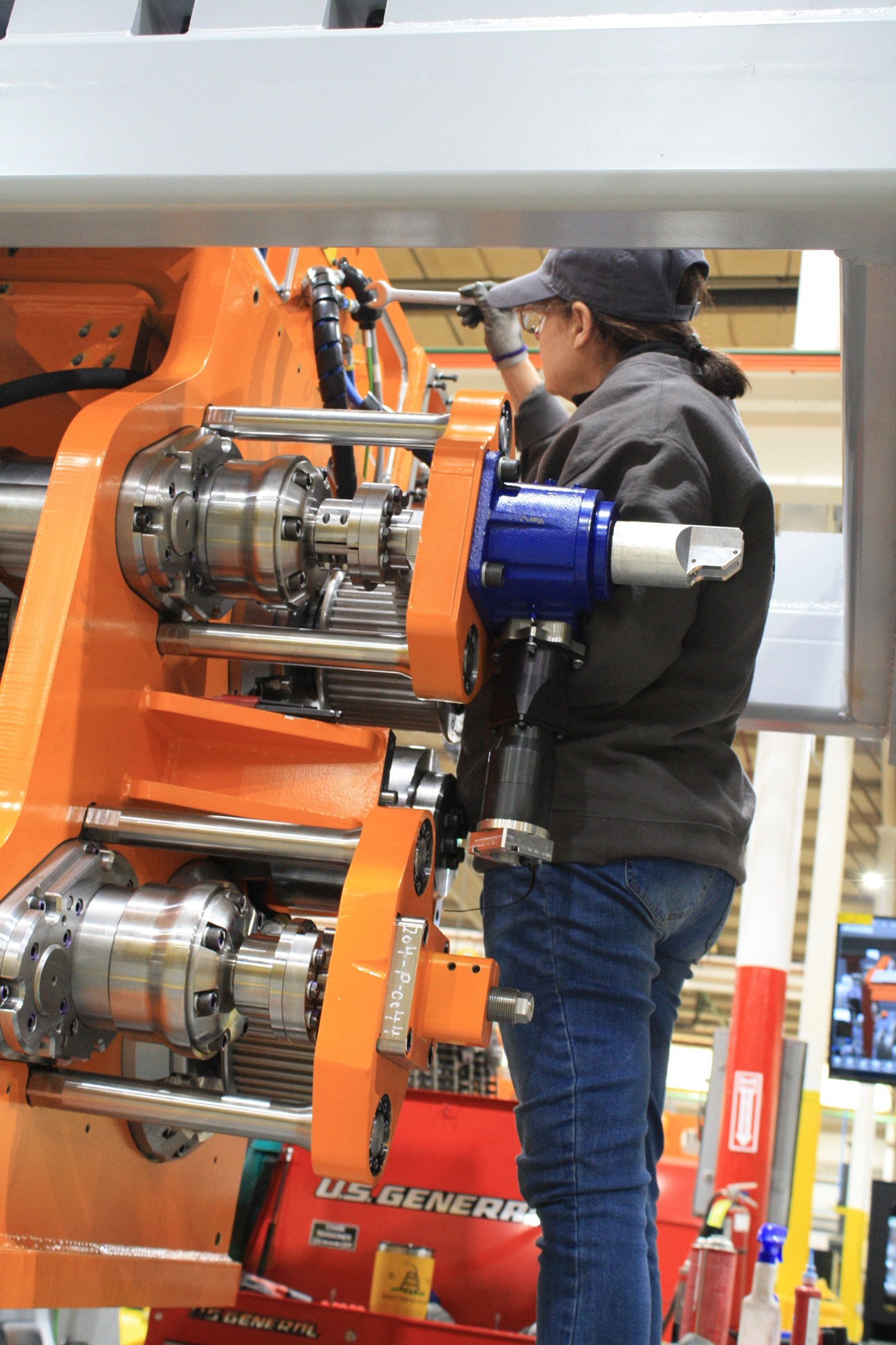 Person holding wrench working on piece of machinery