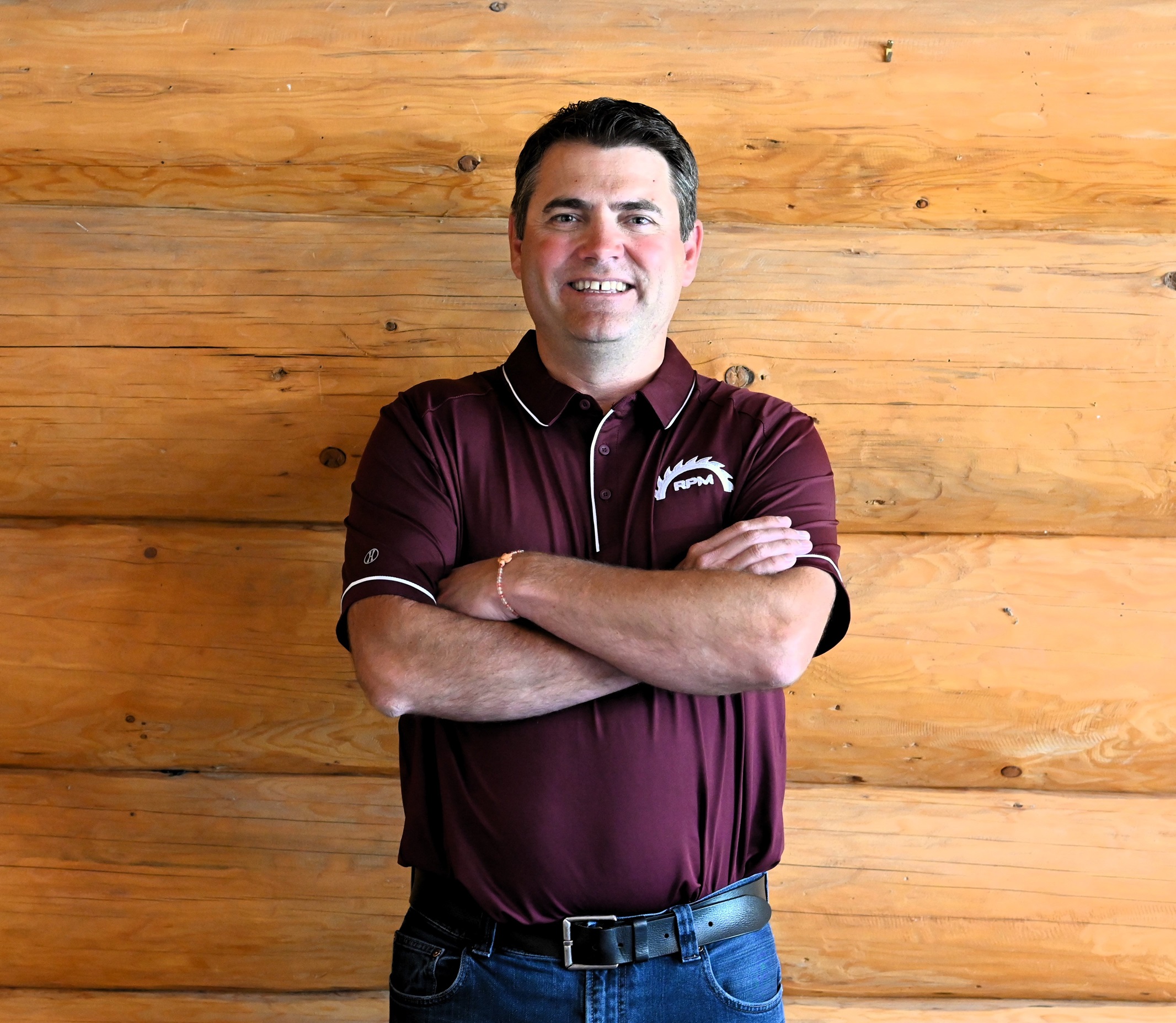Richard Vetter in a red RPM shirt with log wall background