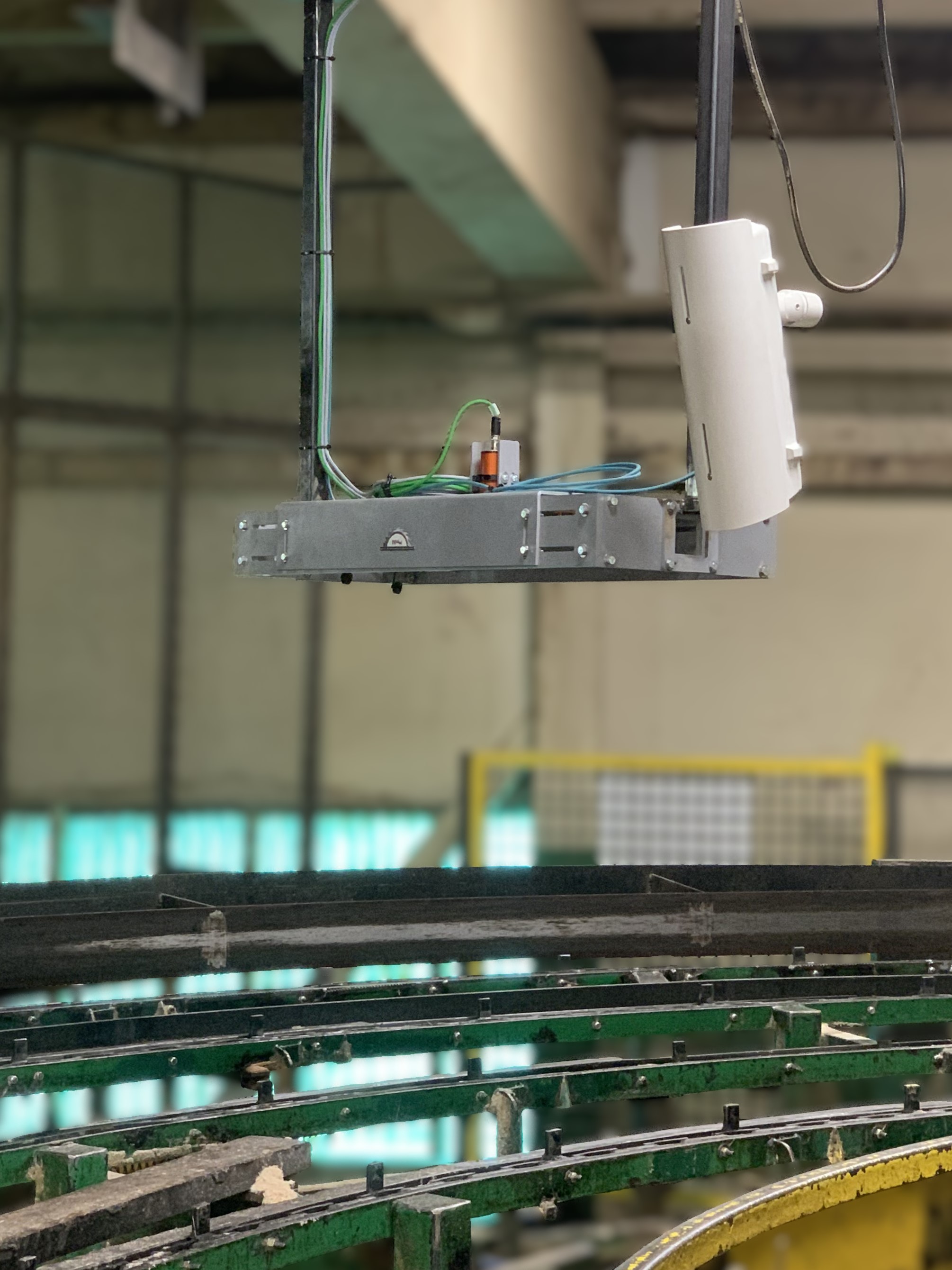 Scanner mounted above a curved track boards travel along